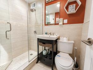 a bathroom with a shower and a toilet and a sink at Lovely 2BR Condo WFH Heart of Downtown Pool Access in Atlanta