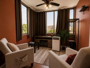 a living room with chairs and a fan and windows at Lovely 2BR Condo WFH Heart of Downtown Pool Access in Atlanta +7 photos