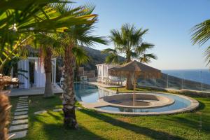 a resort with a swimming pool and palm trees at Blue Vedere in Agia Pelagia