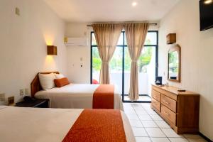 a hotel room with two beds and a window at Surf Olas Altas in Puerto Escondido