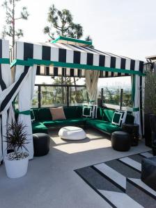 a patio with a green couch under a canopy at Chamberlain West Hollywood in Los Angeles