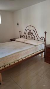 a bed with a wooden frame in a room at guesthouseminturnoit Lucia Sparagna in Minturno +42 photos