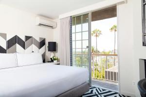 a hotel room with a bed and a balcony at Chamberlain West Hollywood in Los Angeles +40 photos