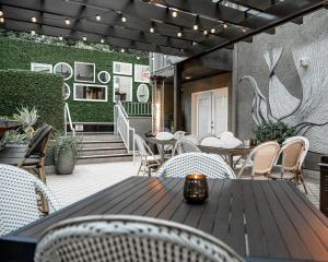an outdoor patio with tables and chairs and plants at Chamberlain West Hollywood in Los Angeles