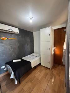 a small bedroom with a bed and a white cabinet at Container Hospedaria Paraty in Paraty