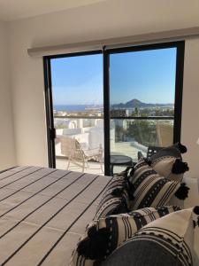 a bedroom with a bed with a view of a balcony at Sunset view Penthouse 302 in Cabo San Lucas +30 photos