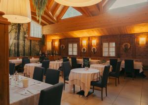 a dining room with tables and chairs and wooden ceilings at Hotel Orso Grigio in Selva di Cadore