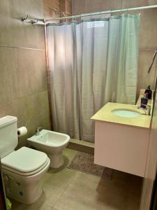 a bathroom with a toilet and a sink and a shower at Departamento en Goya Ctes in Goya +12 photos