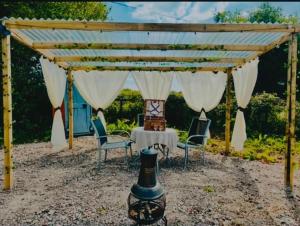 a pergola with a table and chairs under it at Buttys place in Abergavenny