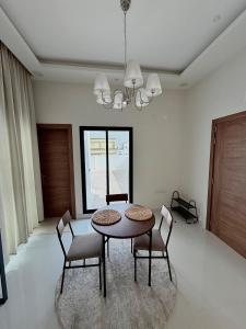 a dining room with a table and chairs and a chandelier at Luxury Cozy 2BR Penthouse in Ḩayl Āl ‘Umayr +13 photos