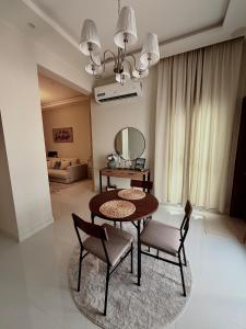 a dining room with a table and chairs and a mirror at Luxury Cozy 2BR Penthouse in Ḩayl Āl ‘Umayr