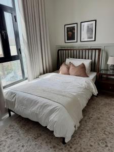 a bed with two pillows on it in a bedroom at Luxury Cozy 2BR Penthouse in Ḩayl Āl ‘Umayr