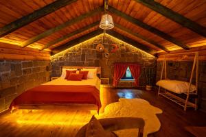 a bedroom with a bed and a stone wall at Dolana Wadi Taş Evleri in Pirinçlik