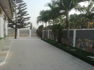 a walkway with palm trees in front of a building at FREDJACKSAIR BnB in Koforidua