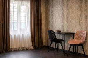 two chairs and a table in a room with a window at Hotel Eden Mestia in Mestia