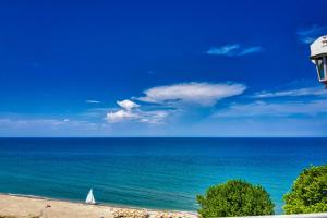 a sailboat on the beach with a blue ocean at Panorama Suites & Spa - Adults Only in Stomio +67 photos