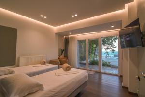 a hotel room with two beds and a balcony at Blue Vedere in Agia Pelagia +43 photos
