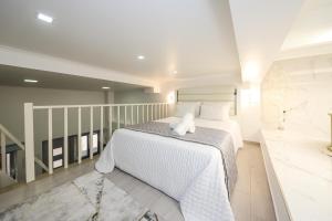 a bedroom with a white bed with a towel on it at Dina Beach House in Nazaré