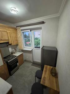 a kitchen with a refrigerator and a table with a cat at Avenue B&B in Vanadzor