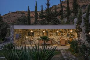 a stone building with lights on it with a mountain in the background at Blue Vedere in Agia Pelagia