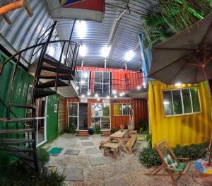 a room with a staircase and a patio with tables and chairs at Container Hospedaria Paraty in Paraty