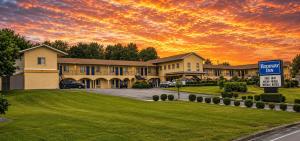 a house with a sign in front of a sunset at Rodeway Inn in Somerset