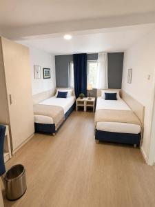 a hotel room with two beds in a room at Hotel Mainbrücke in Kitzingen