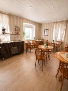 a restaurant with tables and chairs in a room at Hotel Mainbrücke in Kitzingen