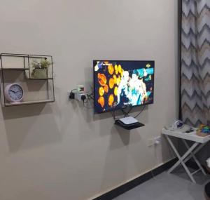 a flat screen tv hanging on a white wall at Migzhome in Dodoma +6 photos