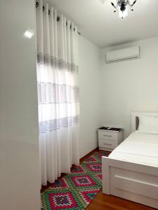 a bedroom with a bed with white curtains and a rug at Home Lin in Lin