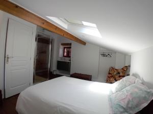 a bedroom with a large white bed and a skylight at Casetta - Appartement dans maisonnette rustique in Cognocoli-Monticchi