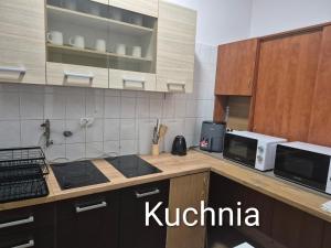 a kitchen with a stove and a microwave at Bursztyn in Władysławowo