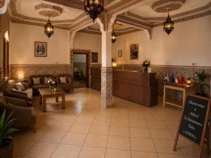 a lobby with a waiting room with couches and tables at Hotel la renaissance tata in Tatta