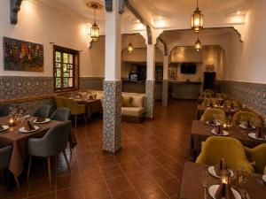 a restaurant with tables and chairs in a room at Hotel la renaissance tata in Tatta