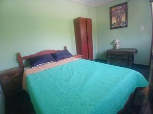 a bedroom with a bed with a blue comforter at Hospedaje Wara in Lozano