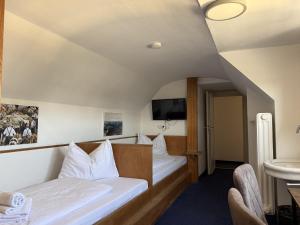 a hotel room with two beds and a tv at Hotel Hasen Kaufbeuren Allgäu in Kaufbeuren