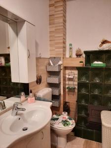 a bathroom with a sink and a toilet and a green cabinet at Apartment Arcadia in Ozalj +38 photos