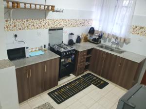 a small kitchen with a stove and a sink at stayscape homes nanyuki in Nanyuki