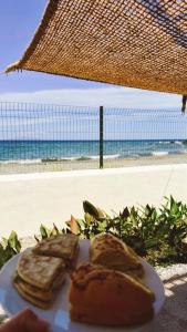 a plate of food with a sandwich on the beach at Cap Almyra, on Lavasina Beach, Erbalunga in Brando