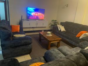 a living room with two couches and a tv at Floma Homes in Nairobi