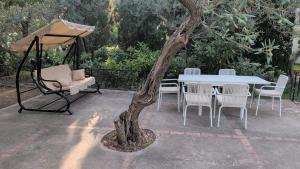 a table and chairs and a table and a tree at Capri Coral Home in Anacapri