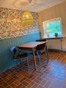 a dining room with a wooden table and chairs at Gästis in Borrby