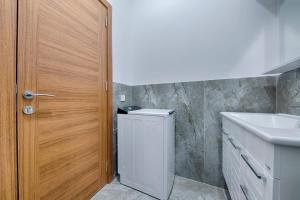 a bathroom with a sink and a washer and dryer at ZIS LUX Sea View in Kravlja +28 photos
