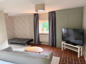 a living room with a couch and a flat screen tv at Gästis in Borrby