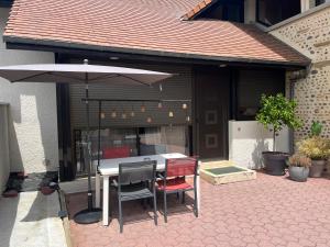 a table and chairs with an umbrella on a patio at Le Sevirqueno in Bougarber