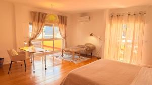a bedroom with a bed and a desk and a table at Oceanfront 2 bedrooms apartment with swimming pool & garage in Cascais +42 photos