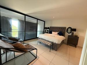 a bedroom with a bed and a chair and a balcony at Cozy Abode by Embassy Gardens in Cantonments +155 photos