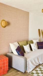 a couch with pillows on it in a room at Cap Almyra, on Lavasina Beach, Erbalunga in Brando