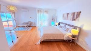 a bedroom with a bed and a table and a desk at Oceanfront 2 bedrooms apartment with swimming pool & garage in Cascais
