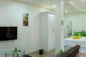a living room with a bed and a tv on a wall at Agape Suites-Room 2-Ground Floor in Soufrière
